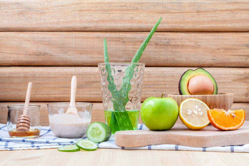 Ingredients für Gesichtsmasken und Peelings: vier Schälchen mit Honig, Quark, Aloe Vera und Avocado.